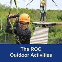 two children on a wooden platform in the air wearing yellow helmets