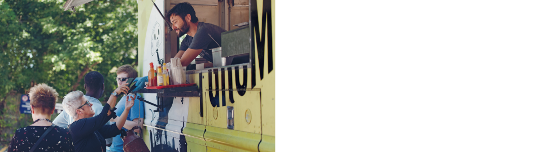 Man in food truck handing food out to a customer