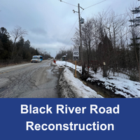 asphalt road in bad condition with ditch running alongside with blue bar with text Black River Road Reconstruction