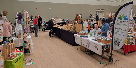 A vendor market with vendors at tables in a large open space