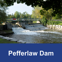 Dam with water surrounded by trees  with blue bar and text Pefferlaw Dam