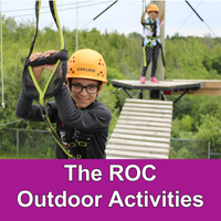 two children on an overhead ropes course with helmets