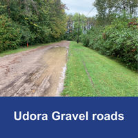 dirt and gravel road with pooled water  with blue bar and text Udora Gravel Road