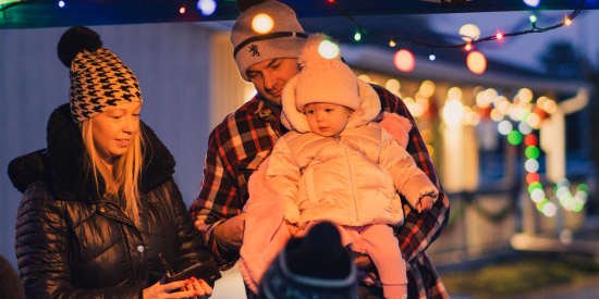 family in winter gear looking at lights