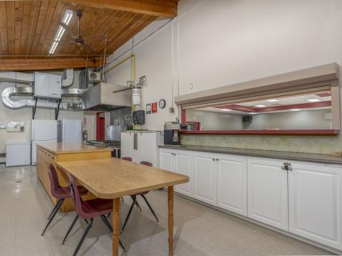 Kitchen area with fridges freezers and stove as well as counters and a coffee maker