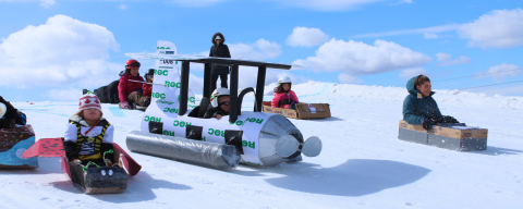 kids on homemade cardboard toboggans going down the hill at the ROC