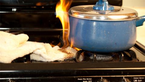 Pot on fire on stove top