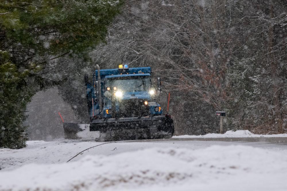 snowplow plowing a snowy road