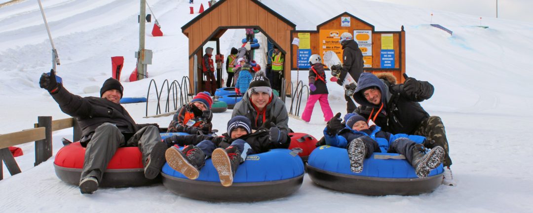 children sitting on tubes outside