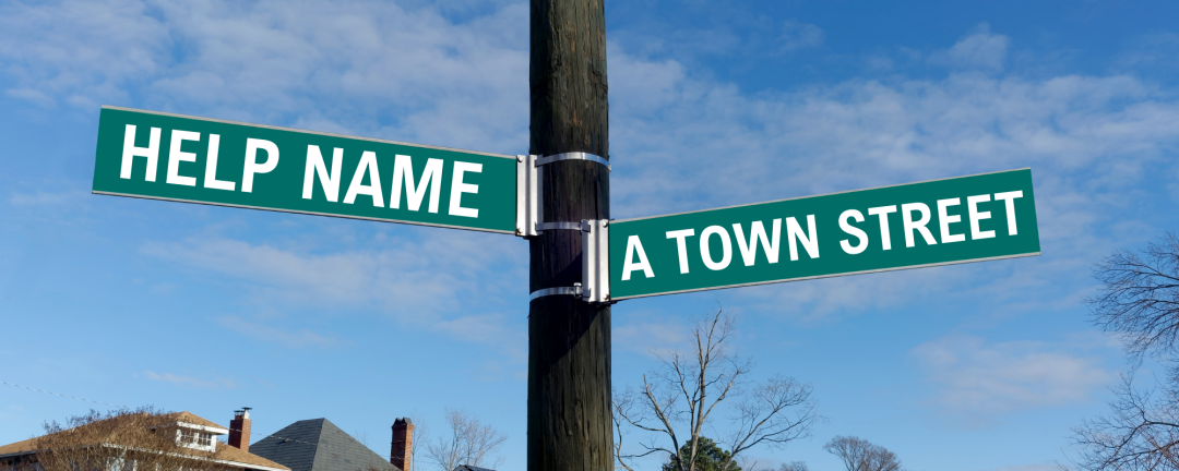 a pole with two street signs on it that say - help name a Town street